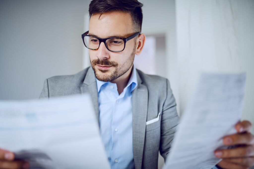 Man in a suit looking at financial statements.